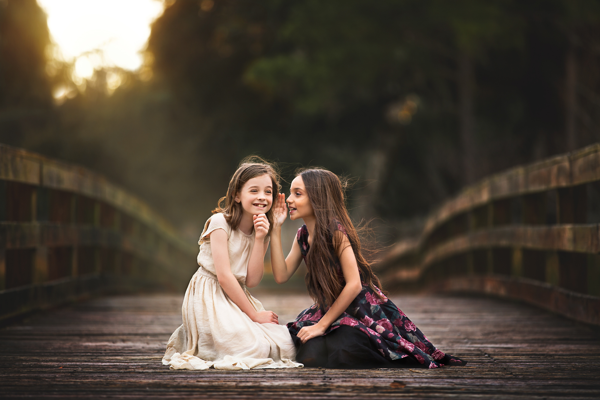 Two girls talking secrets on Discovery Green park in Houston, TX