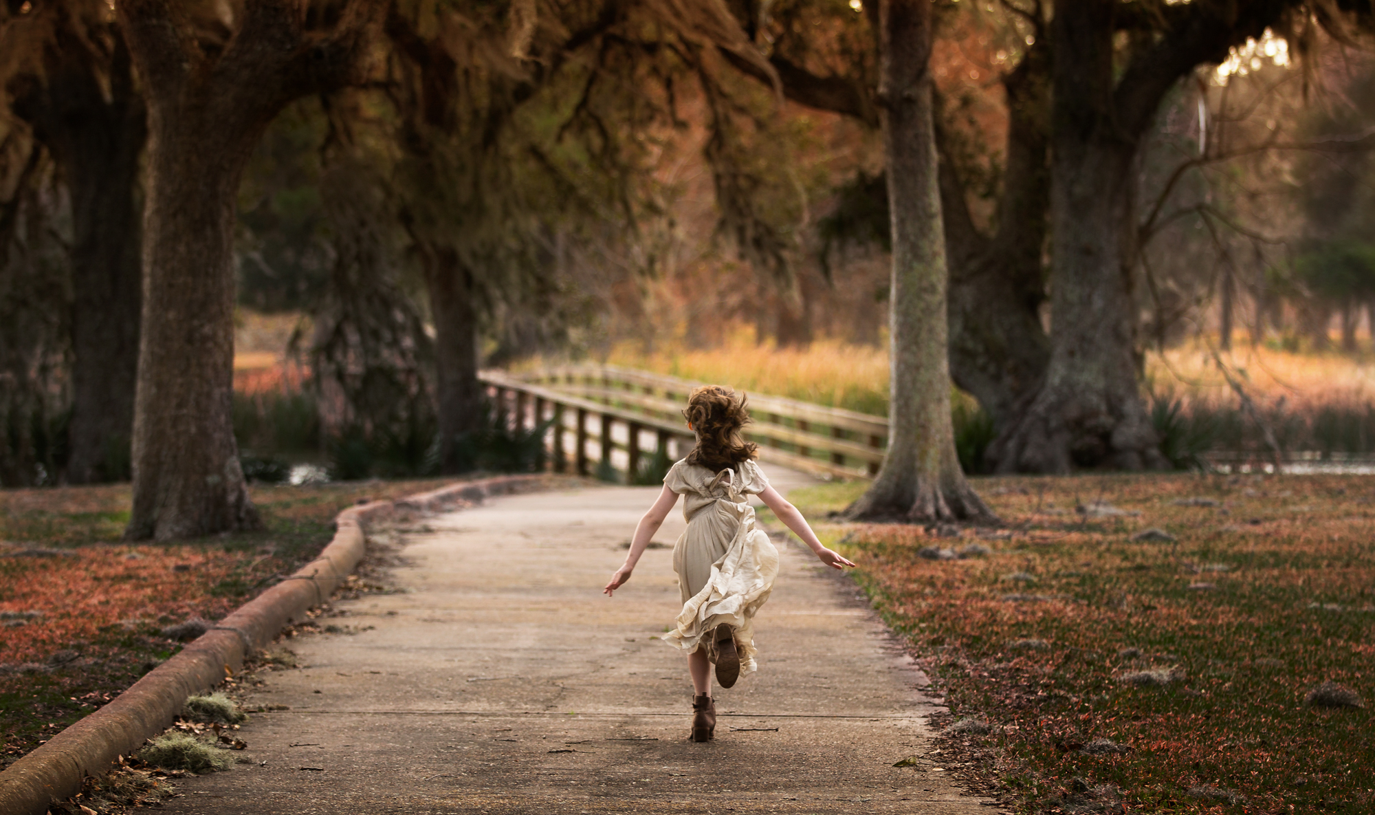 Little girl running freely towards a bridge in a beautiful park where you can take your kids on a weekend in Houston