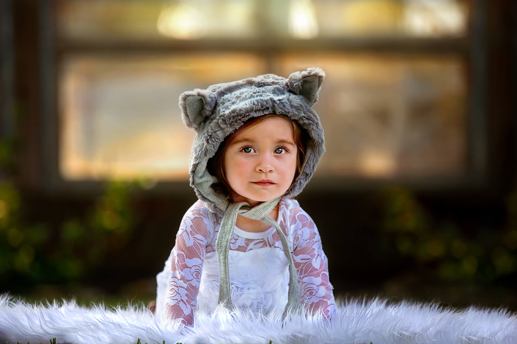Adorable baby girl wearing a stylish outfit and furry bonnet from Baby Depot Houston.