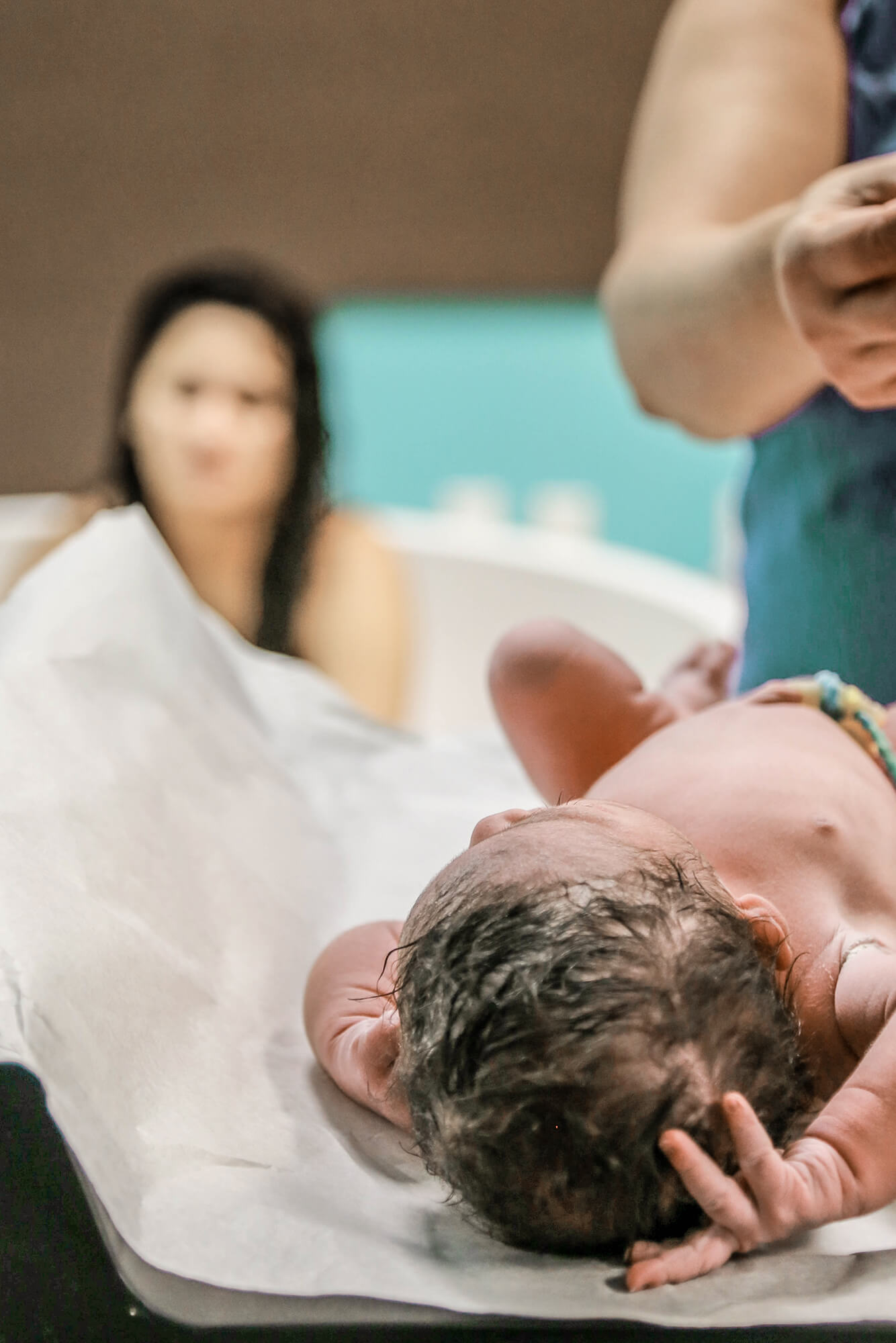 Close up of a baby girl being measured and weighted by her doula in Houston, Texas