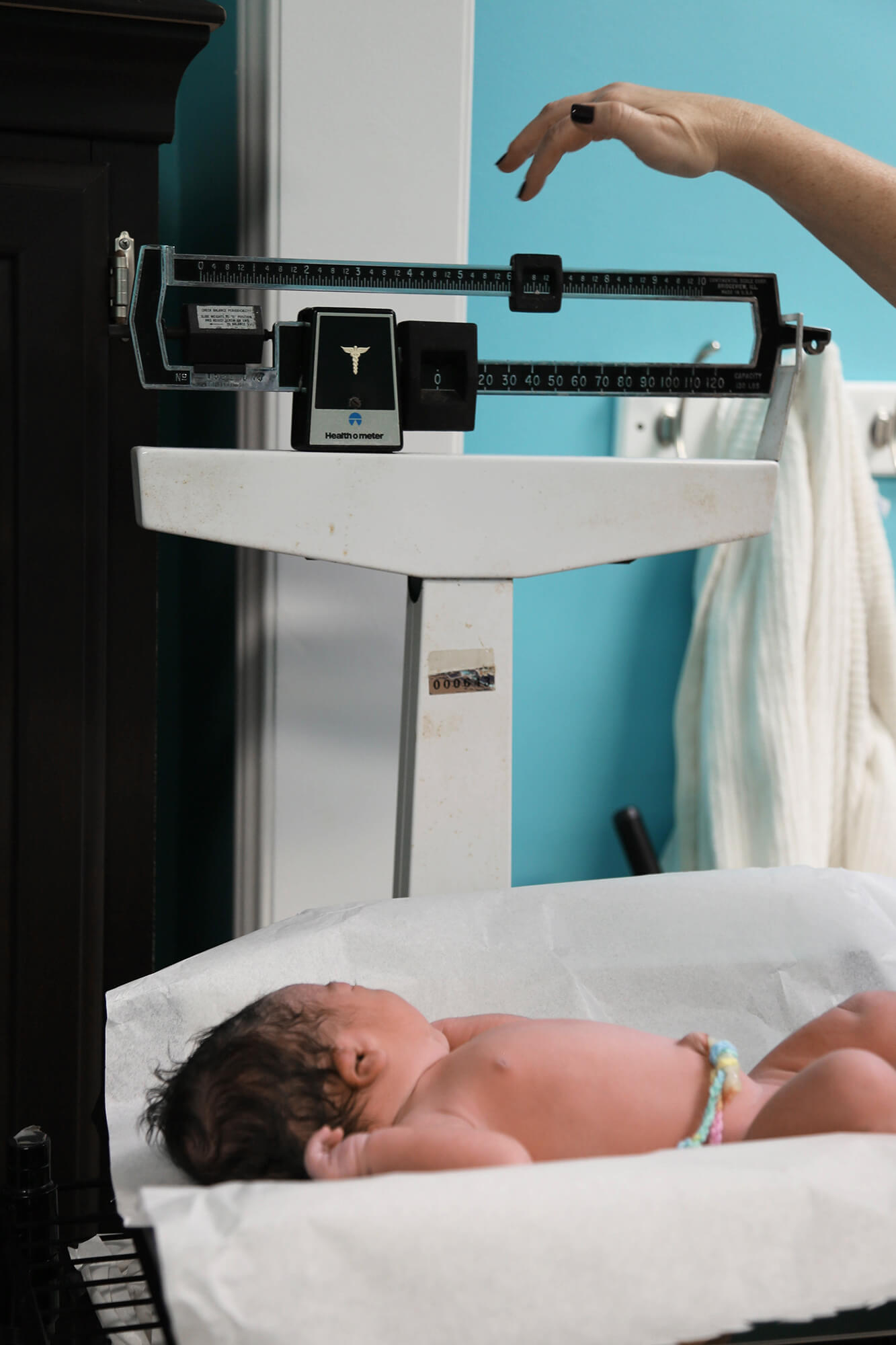 Doula working weighing baby right after her birth
