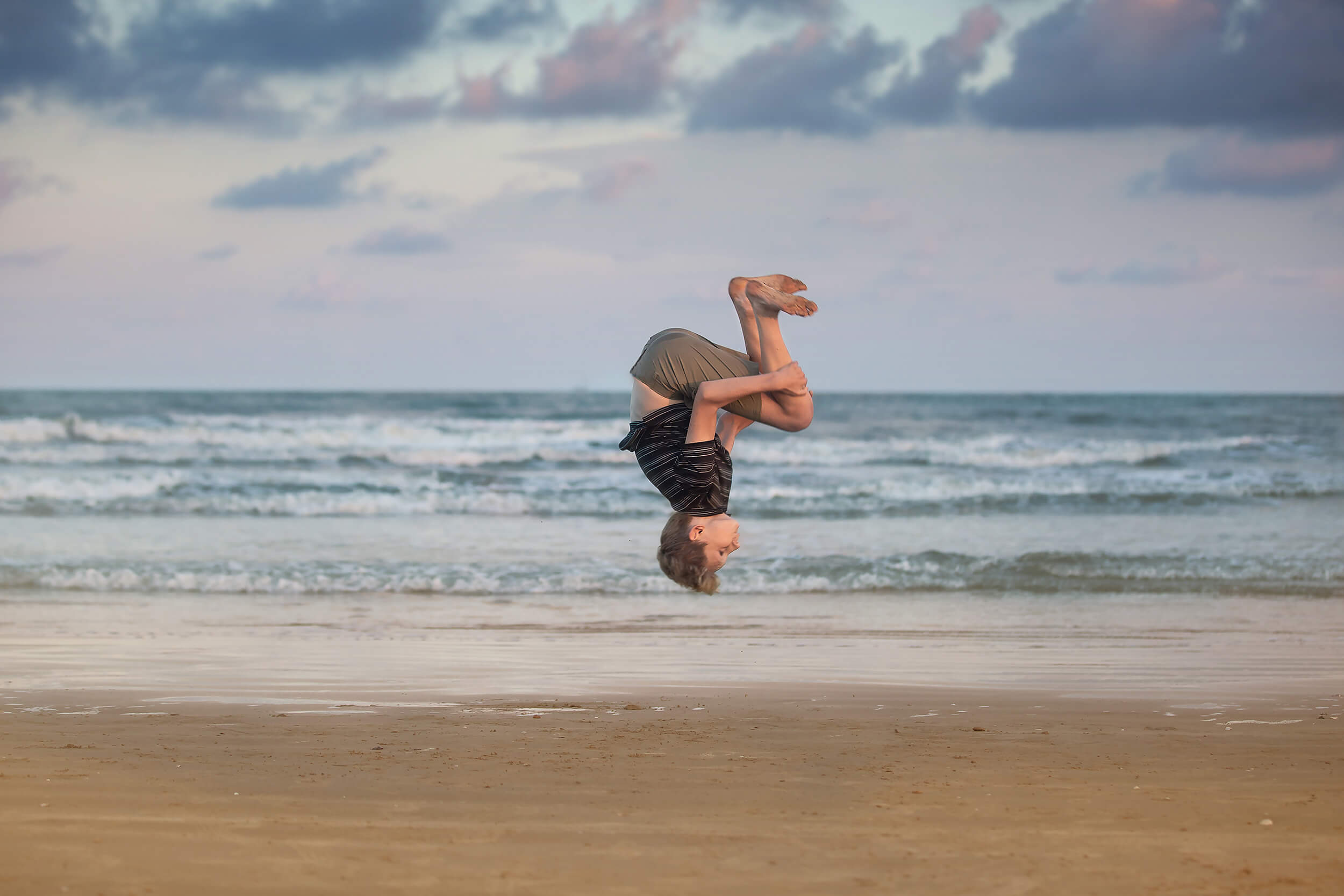 Teenager boy practicing his back flips during a beach summer camp near Houston.
