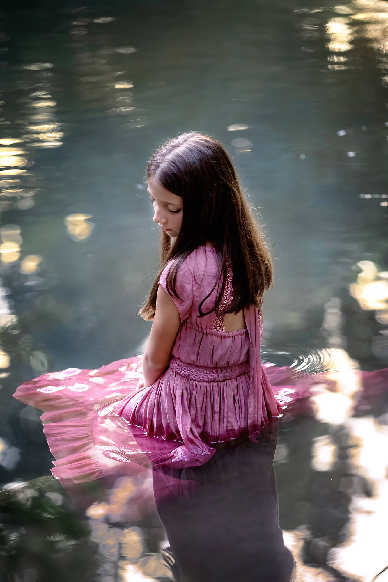 Little girl wearing a pink dress floating on the river in one of the best Hill Country Getaway from Houston.