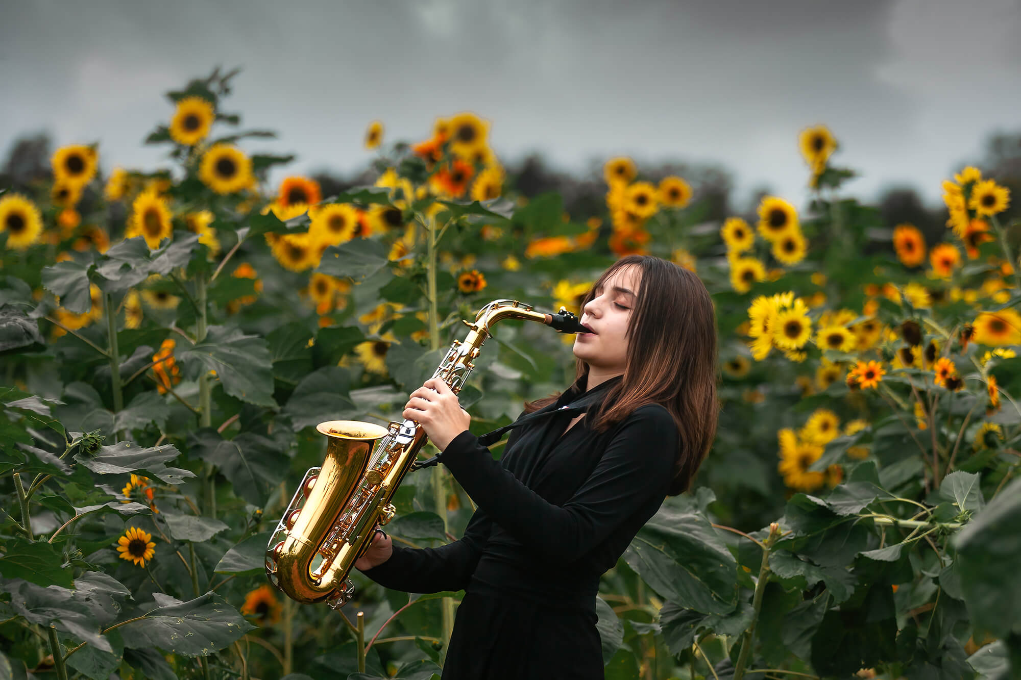 Teenager girl playing the saxophone with sunflowers o the background right next to Vivaldi Music Academy in Houston, Texas.