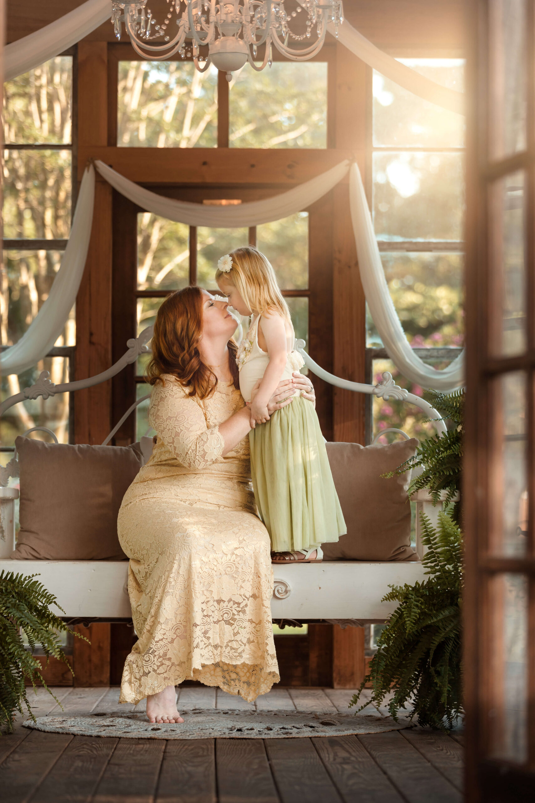 Gorgeous red haired-mom and her sweet daughter inside the beautiful greenhouse at Out Under the Trees in Angleton, TX.